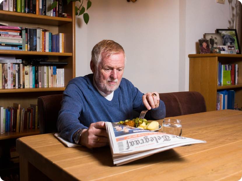 Henk leest de krant terwijl hij eet